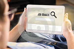 Man trying to find work with online job search engine on tablet.