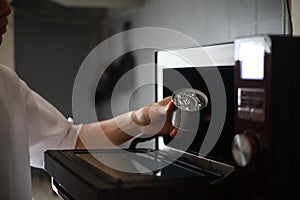 A man trying to heat a can in the microwave