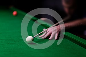 Man trying to hit the ball in billiard