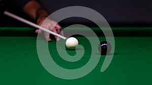 Man trying to hit the ball in billiard