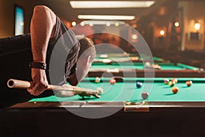 Man trying to hit the ball in billiard.