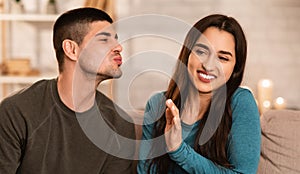 Man trying to kiss a woman, she rejecting him