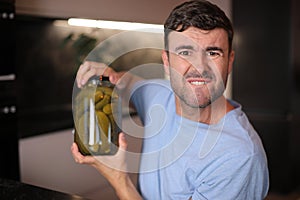 Man trying to open a pickles jar