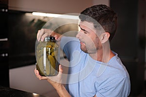 Man trying to open a pickles jar