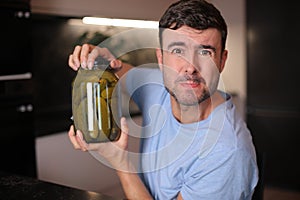 Man trying to open a pickles jar