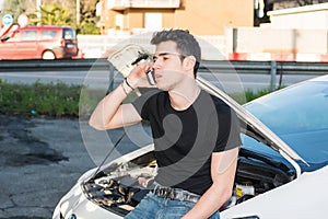 Man trying to repair a car and seeking help photo