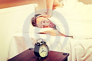 Man trying to sleep, when alarm clock ringing