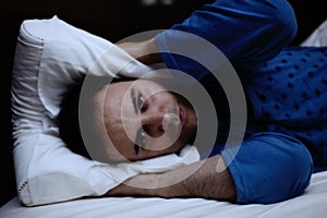Man trying to sleep in his bed