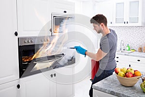 Man Trying To Stop Fire Coming Out From Oven