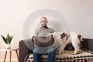 Man trying to work at home, dog seeking attention.