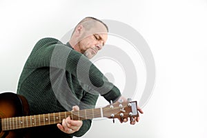 a man tunes a guitar male hands and a guitar close-up of a musician playing an acoustic guitar. Music white background