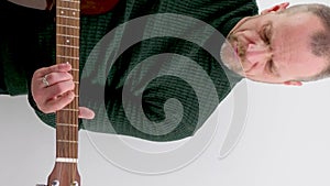 a man tunes a guitar male hands and a guitar close-up of a musician playing an acoustic guitar. Music white background