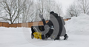 Man tunes snowblower before cleans snow with snow plow at backyard. Install snowplough. Slow motion