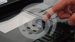 A man tunes the synthesizer by poking the buttons