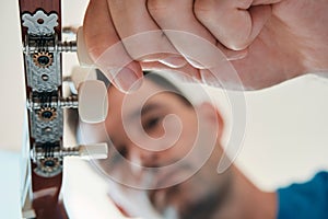 Man Tuning His Acoustic Guitar Before Playing Music