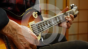 Man tuning his electrical guitar.