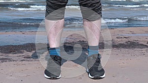 Man with the turn up trousers on the beach near sea