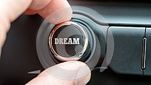 Man turning on a dream button with the word - Dream