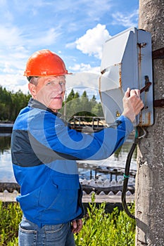 Man turning the power switch in an industrial plant