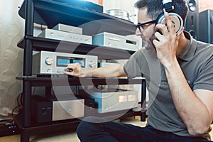 Man turning up the volume on home Hi-Fi stereo