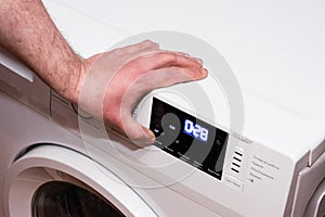 Man turns off the washing machine, hand close up