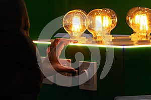 A man turns on round energy-efficient light bulbs in a glass bulb with warm light