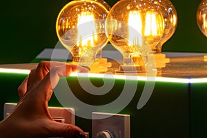 A man turns on round energy-efficient light bulbs in a glass bulb with warm light