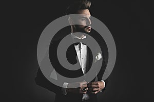 Man in tuxedo adjusting his lounge jacket photo
