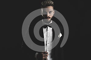 Man in tuxedo adjusting his lounge jacket photo