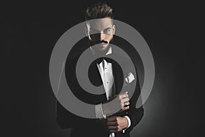 Man in tuxedo fixing his sleeve photo