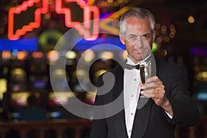 Man in tuxedo drinking champagne in casino