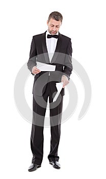 Man in a tuxedo reading the document