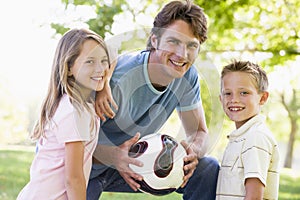 Man and two children outdoors holding volley