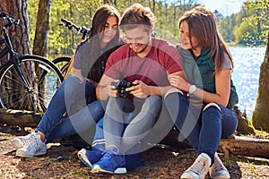 A man and two girls using a compact digital camera on the wild r