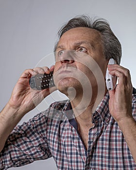 A man with two phones is fed up with being harassed over the phone with unwanted business proposals