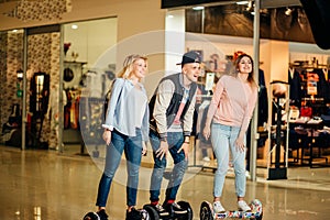 Man and two woman riding on Hoverboard in mall