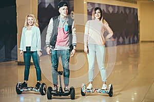 Man and two woman riding on Hoverboard in mall
