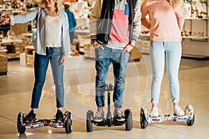 Man and two woman riding on Hoverboard in mall