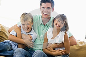 Man and two young children in living room smiling