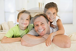 Man and two young children sitting in living room