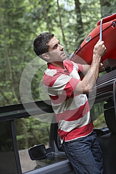 Man Tying Kayak On Car Roof