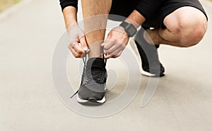 Man tying running shoes laces getting ready for run