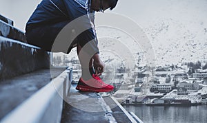 A man tying running shoes, preparing for running in winter. healthy lifestyle