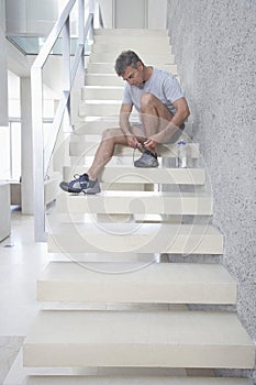 Man Tying Shoelace On Steps