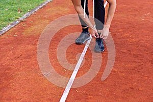 Man tying shoes on the race track