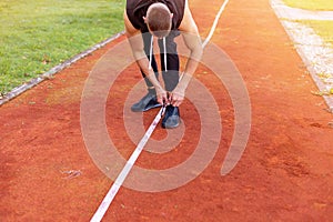 Man tying shoes on the race track
