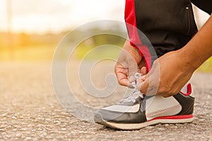 Man tying shoes at roadside.Or sport man tying shoes.