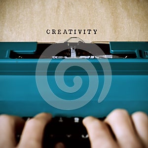 Man typewriting the word creativity photo