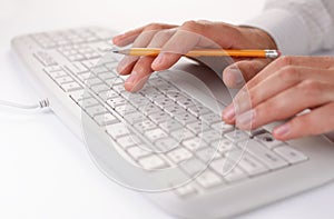 Man typing on a computer keyboard at work