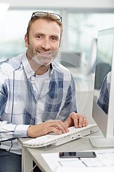 man typing keyboard computer in workplace